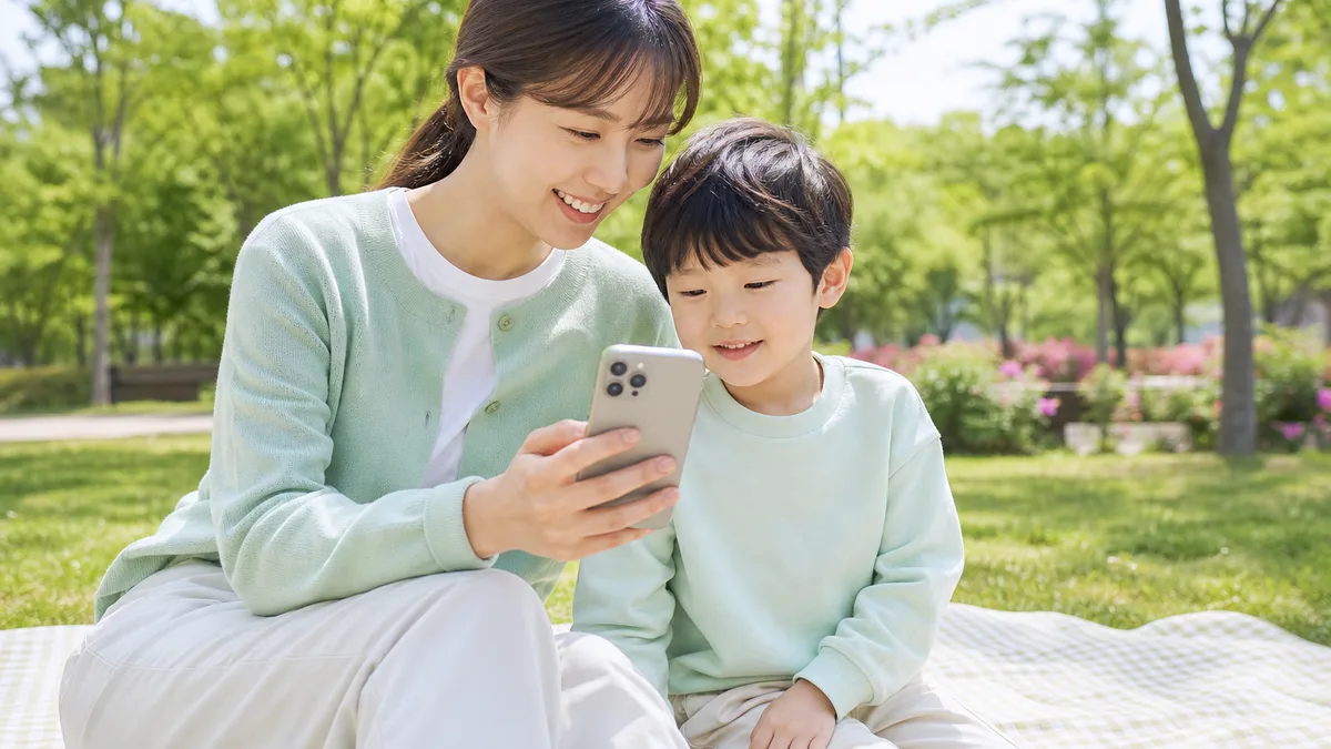 공원에서 보호자와 아이가 발달지원 앱을 함께 확인하는 모습